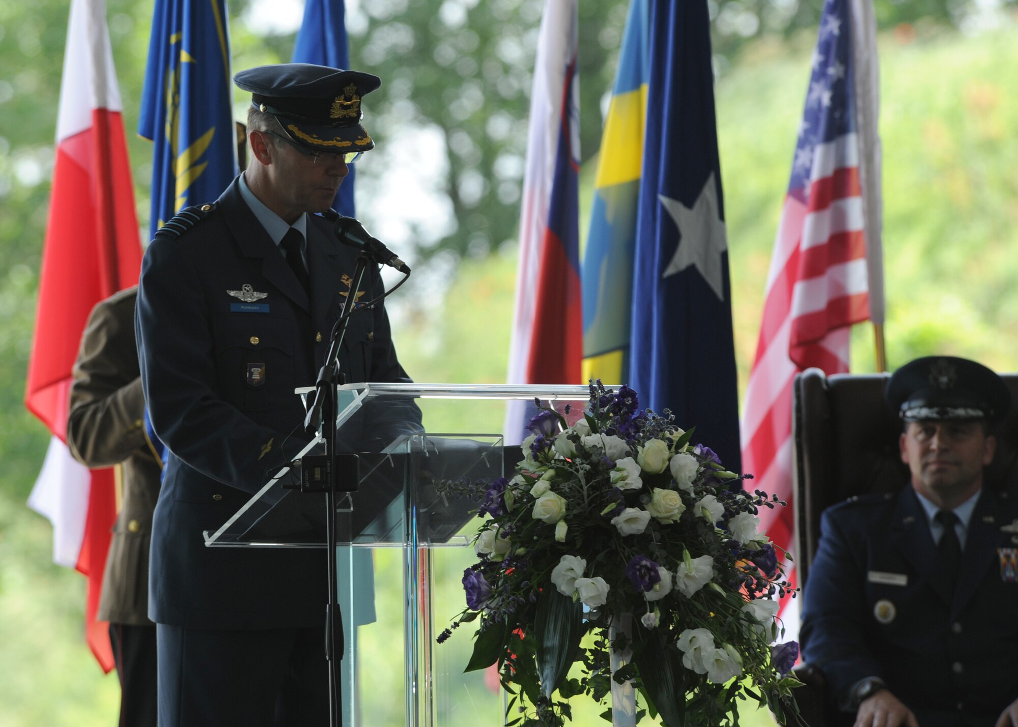 PAPA AIR BASE, Hungary --  Col. Frank Rombouts (Center), Royal Netherlands Air Force commander, addresses the crowd while Brig. Gen. Thomas Sharpy (Right), Director of Plans, Programs and Analyses for U.S. Air Forces in Europe-Air Forces Africa, looks on, during an Assumption of Command ceremony here June 12. Rombouts is the third commander to take control of the HAW since the Wing's inception in 2009. U.S. Air Force Photo By Tech. Sgt. Patrick Mitchell