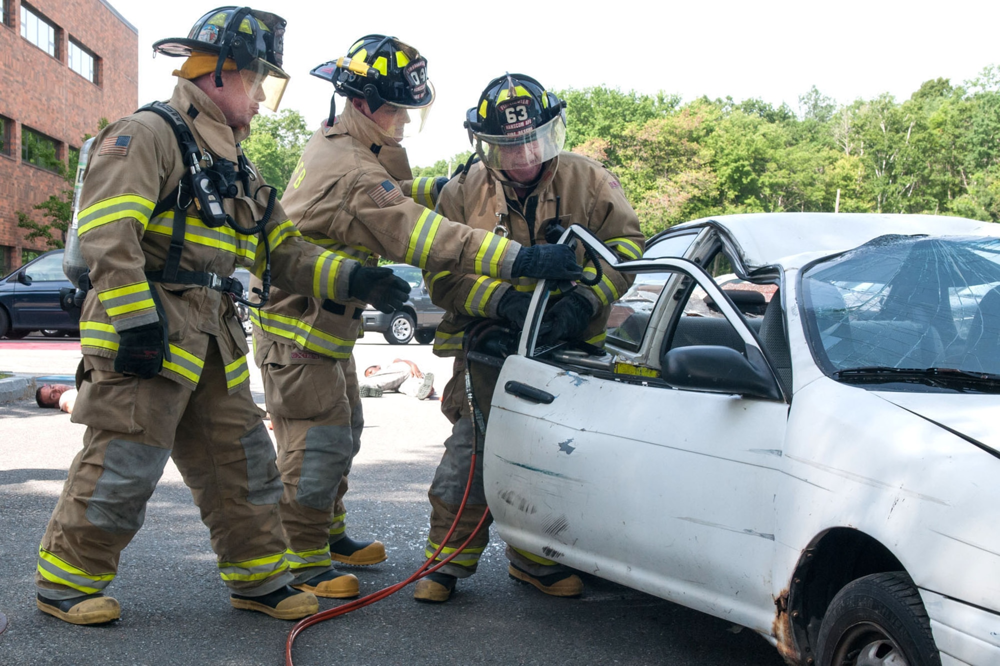 HANSCOM AIR FORCE BASE, Mass. - Firefighters operate the Jaws of Life to rescue a simulated passenger from a vehicle involved in a collision as part of a Consolidated Unit Inspection scenario June 7. The scenario is designed to measure the effectiveness of emergency personnel to manage a major accident on base. Following the readiness portion of the CUI, a full week of rigorous compliance inspections by Air Force Materiel Command inspectors looking at hundreds of inspection items across the installation took place. (U.S. Air Force photo by Rick Berry)