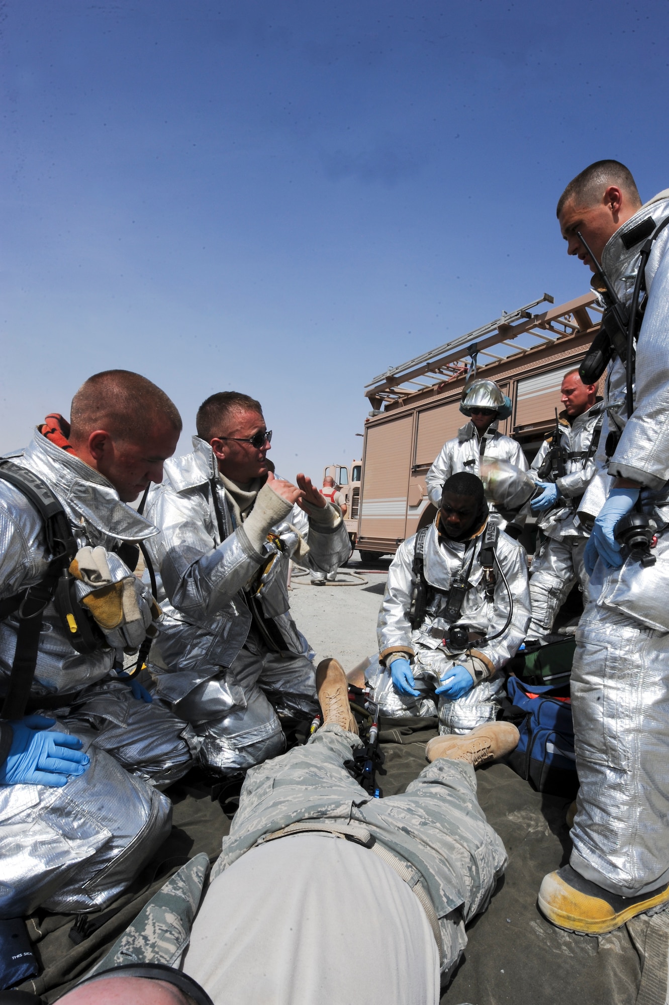U.S. Air Force Senior Airman Braden Kohl (second from left), 380th Expeditionary Civil Engineer Squadron firefighter, explains to fellow firefighters on how to treat different types of wounds during an exercise scenario at an undisclosed location in Southwest Asia Jun 11, 2013. The exercise allowed firefighters to experience real world situations they might encounter. (U.S. Air Force photo by Staff Sgt. Joshua J. Garcia)