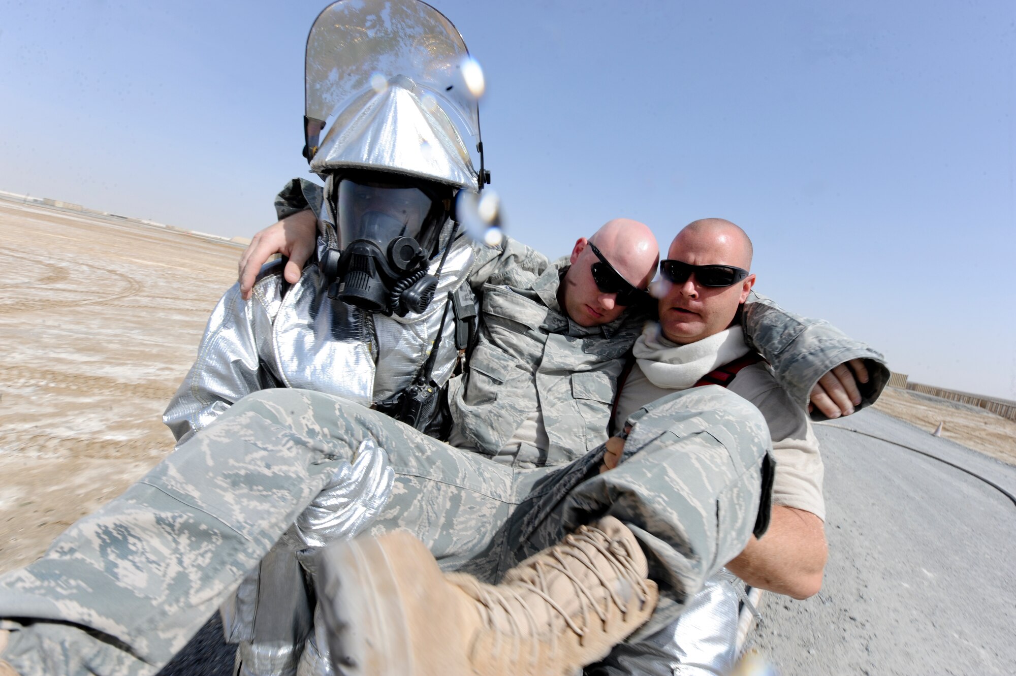 U.S. Air Force Airman 1st Class Allen Hayes (left), and U.S. Air Force Tech. Sgt. Troy Romans, both 380th Expeditionary Civil Engineer Squadron firefighters, carry out Staff Sgt. Matthew McNutt, a simulated victim, during a training exercise at an undisclosed location in Southwest Asia June 10, 2013. After McNutt was removed from the scene he was treated for any possible injuries. Hayes is native to St. Thomas, U.S. Virgin Islands, and is deployed from Kadena Air Base, Japan. Romans calls Port St. Lucie, Fla. home, and is deployed from Mountain Home Air Force Base, Idaho. (U.S. Air Force photo by Staff Sgt. Joshua J. Garcia)