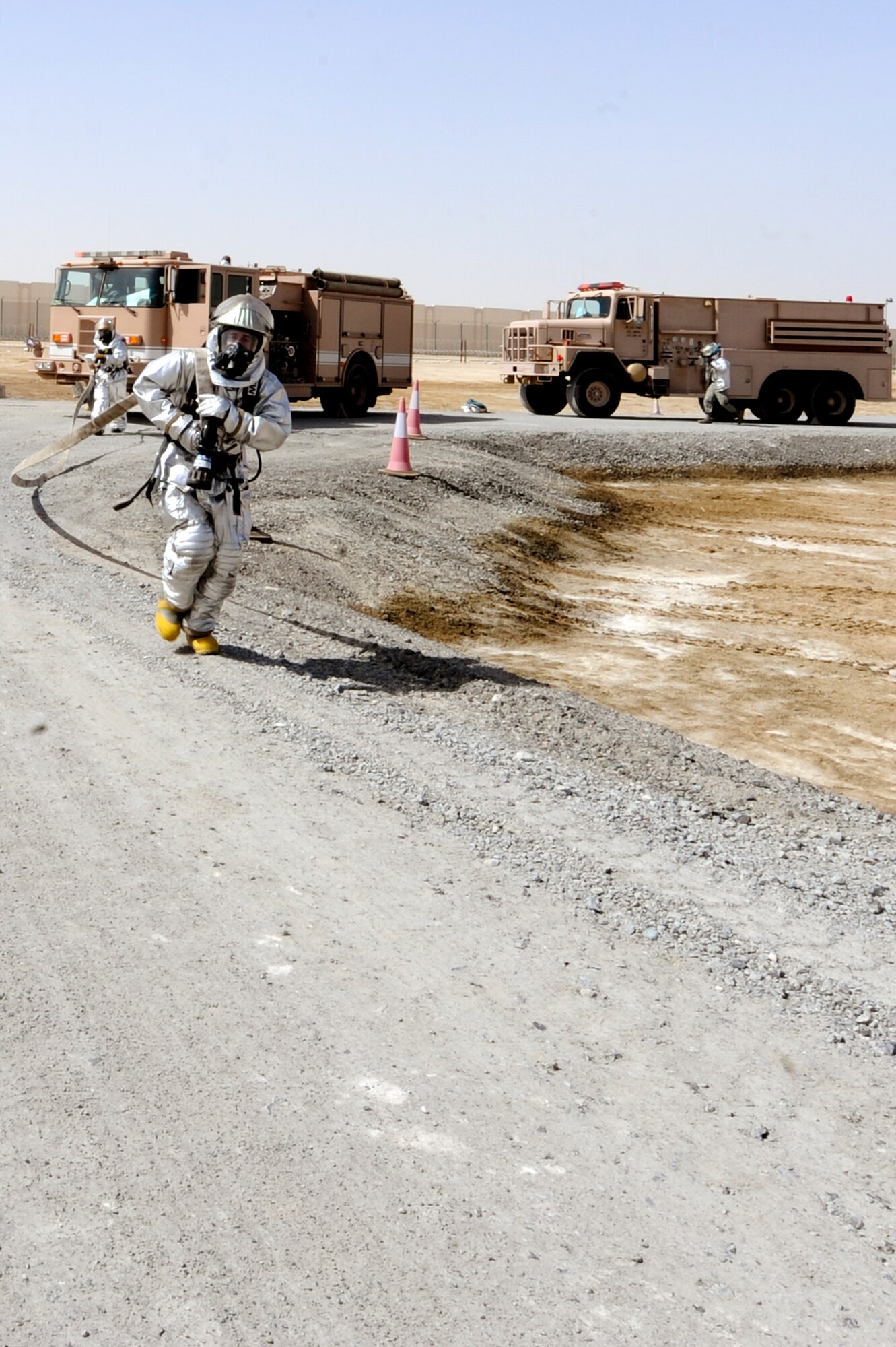 U.S. Air Force Airman 1st Class Chris Parker, 380th Expeditionary Civil Engineer Squadron firefighter, pulls a hose out from the fire truck during a training exercise at an undisclosed location in Southwest Asia, June 10, 2013. Firefighters extinguish a simulated fire and provide medical treatment to injured personnel on scene. Parker is a native of Wilson, N.C., and is deployed from Seymour Johnson Air Force Base, N.C. (U.S. Air Force photo by Staff Sgt. Joshua J. Garcia)