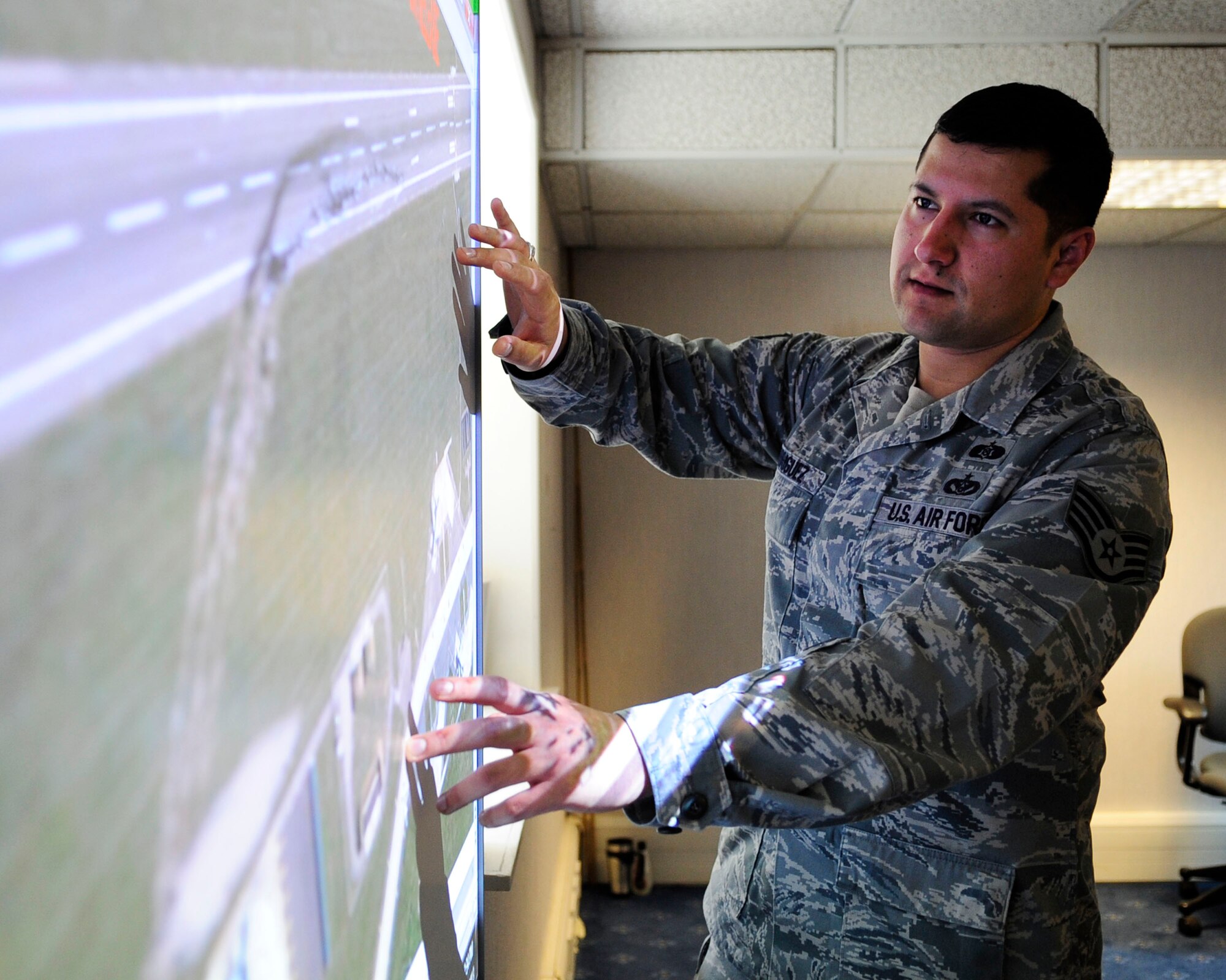 Staff Sgt. David Rodriguez, 100th Air Refueling Wing NCO in charge of wing exercises, reviews base maps from a previous exercise scenario June 12, 2013, at RAF Mildenhall, England. (U.S. Air Force photo by Staff Sgt. Jerilyn Quintanilla/Released)