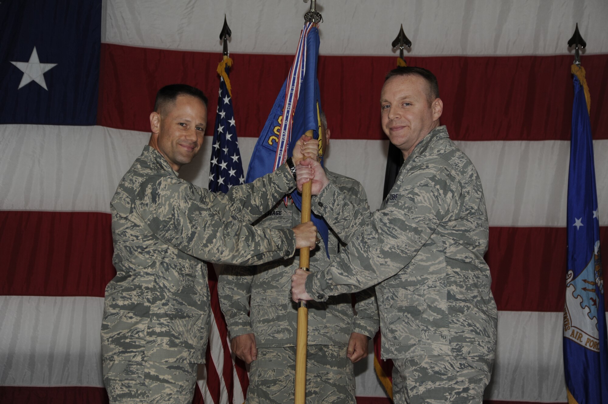 Colonel Michael M. O'Connor, 386th Expeditionary Maintenance Group commander, left, passes the 386th Expeditionary Aircraft Maintenance Squadron guidon to Maj. Donny L. Bagwell during a change of command ceremony at an undisclosed location in Southwest Asia June 13, 2013. Bagwell assumed command of the 386th EAMXS from Lt. Col. Robert W. Gilliland. (U.S. Air Force photo by Master Sgt. Christopher A. Campbell)