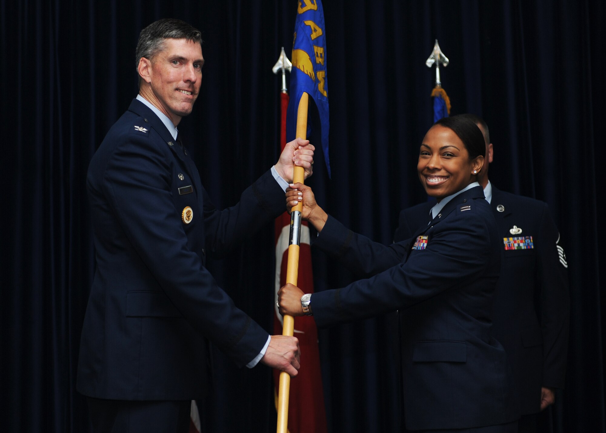 Col. Chris Craige, 39th Air Base Wing commander, passes the squadron guidon to Capt. Mishaun Smith, 39th Comptroller Squadron commander, during the 39th CPTS change of command ceremony June 12, 2013, at Incirlik Air Base, Turkey. (U.S. Air Force photo by Senior Airman Chase Hedrick/Released)
