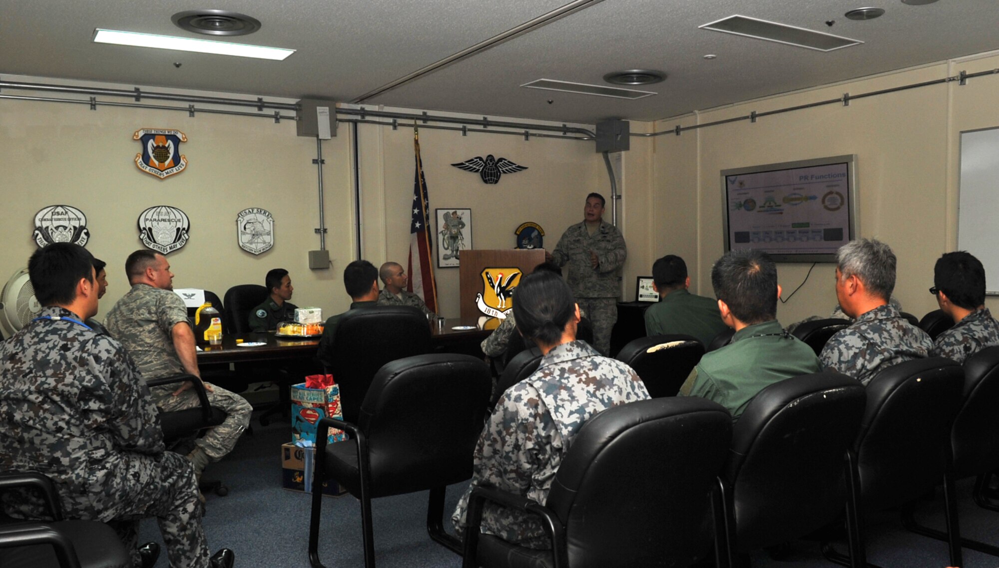 U.S. Air Force Lt. Col. Glen Frazier, 31st Rescue Squadron commander, briefs the squadron’s mission to Japan Air Self Defense Force members during a 31st RQS visit on Kadena Air Base, Japan, June 12, 2013. The JASDF members learned about the differences between JASDF and U.S. Air Force rescue squadron mission at the briefing. (U.S. Air Force photo by Naoto Anazawa/Released)