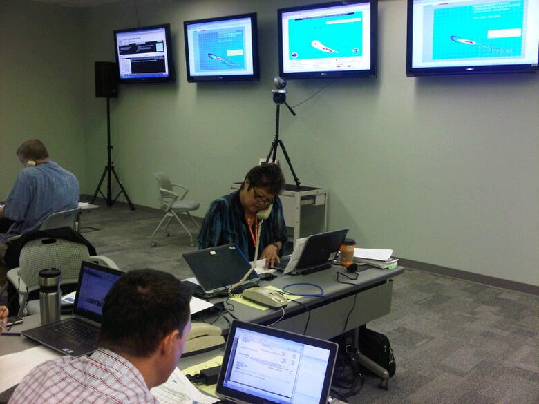 Lolly Silva, USACE-Pacific Ocean Division’s Readiness and Contingency Operations officer calls the state Emergency Operations Center to inject an event from the exercise Master Scenario Events List, at the Sim Cell for Exercise Makani Pahili 2013.  Pacific Ocean Division’s Readiness and Contingency Operations Division supported the annual hurricane preparation exercise, which was coordinated by the state Civil Defense and the Hawaii National Guard.