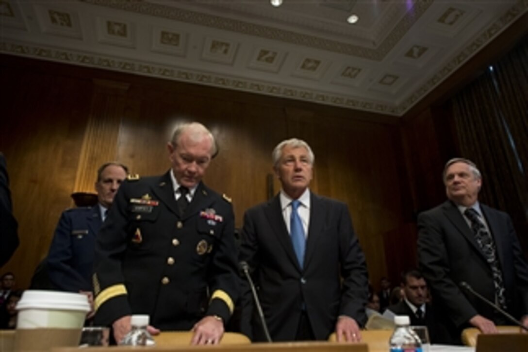 Secretary of Defense Chuck Hagel, center, Chairman of the Joint Chiefs of Staff Gen. Martin E. Dempsey, left and Under Secretary of Defense (Comptroller) and Chief Financial Officer Robert F. Hale, right, take their seats to begin testimony before the Senate Budget Committee in the Dirksen Senate Office Building in Washington, D.C., on June 12, 2013.  Hagel, Dempsey and Hale are defending the president’s request for $526.6 billion for the Defense Department’s fiscal year 2014 budget.  