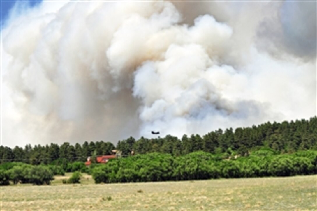 A UH-60 Black Hawk helicopter flies into thick smoke to release water during the Black Forest fire in El Paso County, Colo., June 12, 2013. The pilots and crew chiefs are assigned to the 4th Infantry Division's 2nd General Support Aviation Battalion, 4th Aviation Regiment, 4th Combat Aviation Brigade.