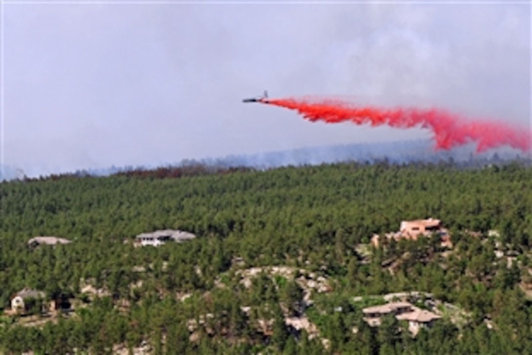 An aircraft releases a fire-retardant solution to help stop the spreading Black Forest fire in El Paso County, Colo., June 12, 2013.