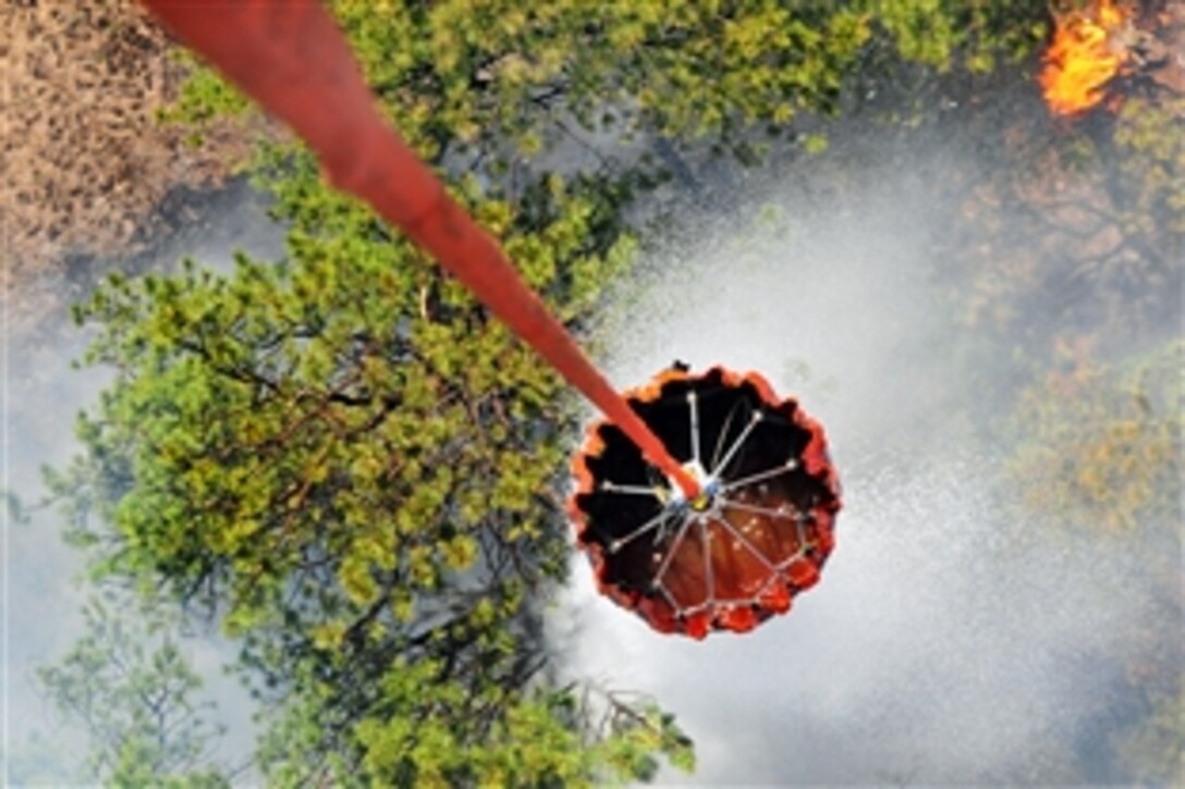 A UH-60 Black Hawk helicopter flies into thick smoke while using a Bambi bucket to release water during the Black Forest fire in El Paso County, Colo., June 12, 2013. The pilots and crew chiefs are assigned to the 4th Infantry Division's 2nd General Support Aviation Battalion, 4th Aviation Regiment, 4th Combat Aviation Brigade.