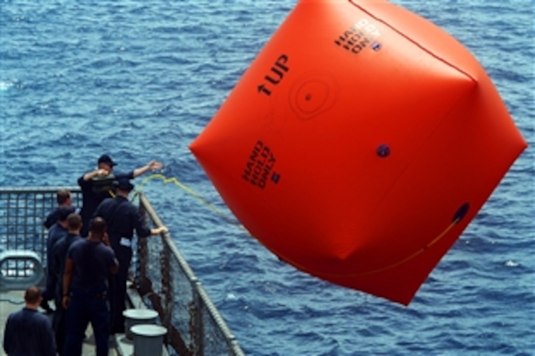 U.S. Navy sailors deploy a surface target, known as a "Killer Tomato," during a live-fire exercise in the Straits of Singapore, June 12, 2013. The USS Freedom is conducting sea trials in preparation for Cooperation Afloat Training Malaysia, an annual naval exercise between the United States and nine partner nations in Southeast Asia.