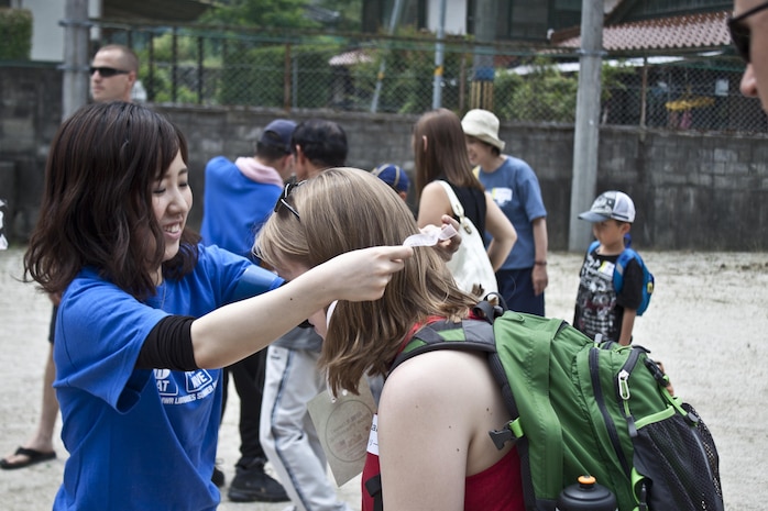 Mizuho Sugiyama, rice-planting event participant, places an award around Natalie Tice’s neck after the rice planting, which took place June 8, 2013. The award included a five-yen coin, which is the only Japanese currency to have a rice plant emblazoned on it.