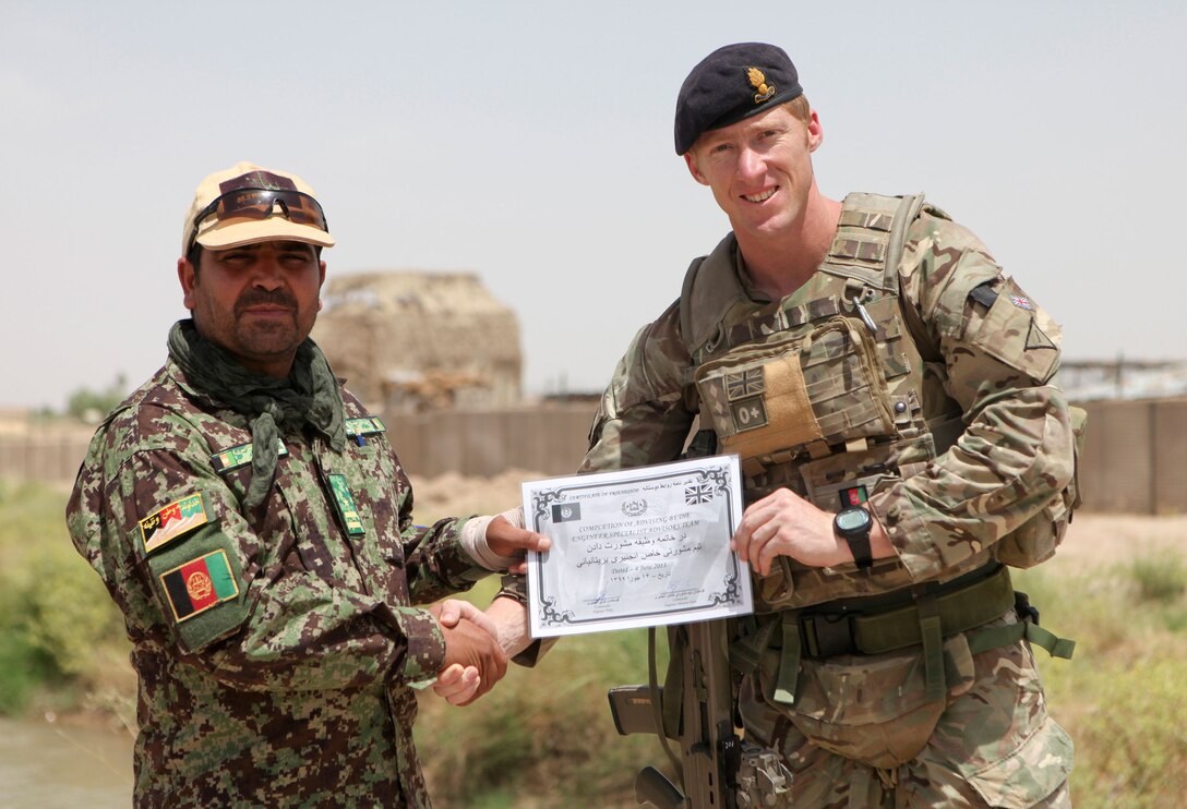 Royal Engineers Capt. Selwyn Fisher poses with the commanding officer of the Engineering Tolai, 4th Combat Support Kandak, 3rd Brigade, 215 Corps, near Patrol Base Sparta June 5. Fisher, a member of  Kandak Advisor Team 40, presented the ANA with a certificate of completion which marked the end of hands-on support to the tolai. All Security Force Assistance provided within the 215 Corps is now conducted at the kandak, or battalion, level and higher. (Photo by U.S. Marine Sgt. Bobby J. Yarbrough)