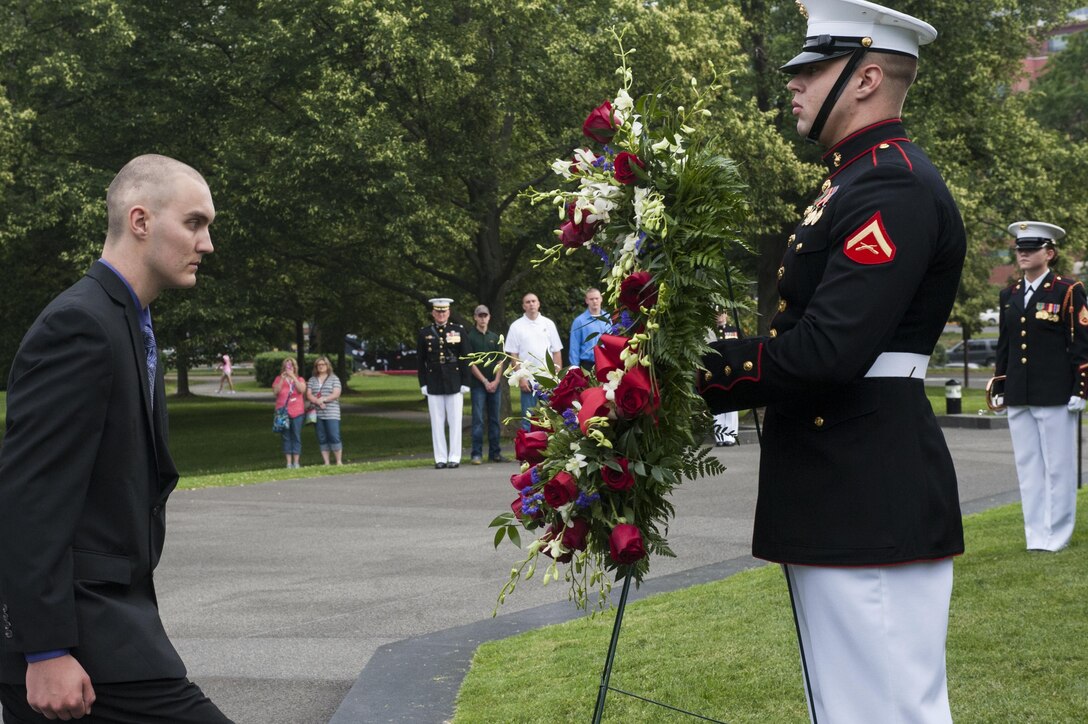 Daran Wankum, the most recent honorary Marine in Marine Corps history, marches up to Lance Cpl. Brian Rochelle, body bearer with Marine Barracks Washington, D.C., to help lay a wreath at the Marine Corps War Memorial during a ceremony for Wankum in Arlington, Va., June 13. Wankum was named an honorary Marine on June 11 due to an illness that came up during the enlistment process that prevented him from starting recruit training. He is currently in Washington as a special guest of the commandant of the Marine Corps and the Barracks.