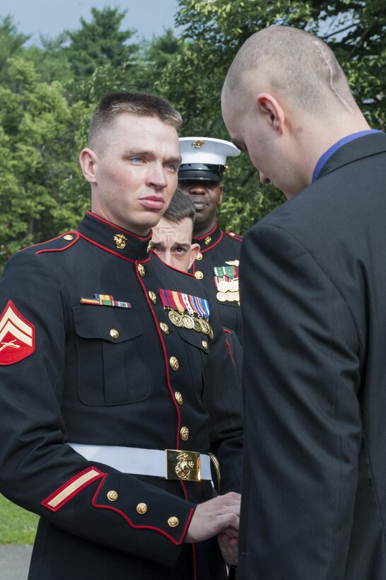 Cpl. Jack Woodworth, Marine Barracks Washington, D.C., ceremonial firing party noncommissioned officer in charge, presents Daran Wankum, the most recent honorary Marine in Marine Corps history, with a Marine emblem from his cover after a wreath-laying ceremony for Wankum at the Marine Corps War Memorial in Arlington, Va., June 13. Wankum was named an honorary Marine on June 11 due to an illness that came up during the enlistment process that prevented him from starting recruit training. He is currently in Washington as a special guest of the commandant of the Marine Corps and the Barracks.