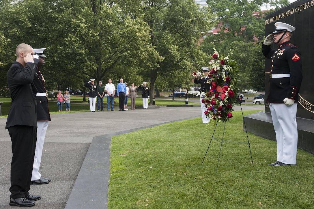 Daran Wankum, the most recent honorary Marine in Marine Corps history, along with his family and Marines from Marine Barracks Washington, D.C., render honors as taps plays during a wreath-laying ceremony for Wankum at the Marine Corps War Memorial in Arlington, Va., June 13. Wankum was named an honorary Marine on June 11 due to an illness that came up during the enlistment process that prevented him from starting recruit training. He is currently in Washington as a special guest of the commandant of the Marine Corps and the Barracks.