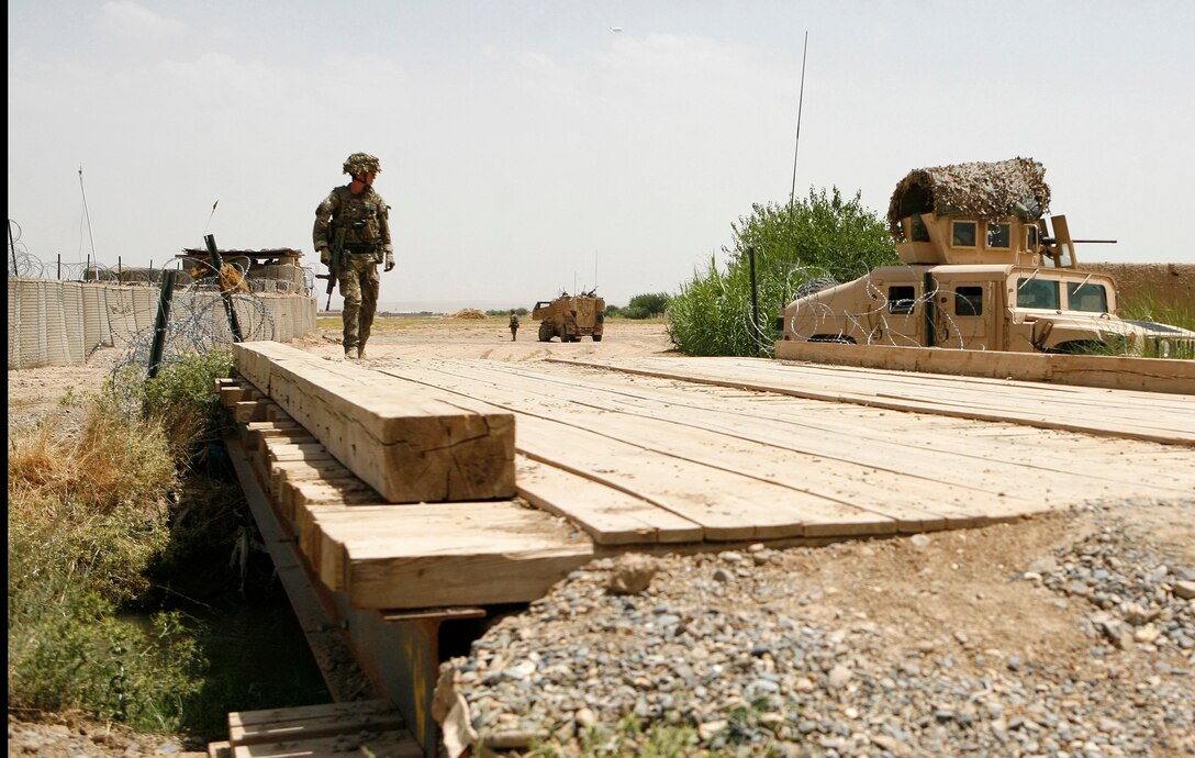 LASHKAR GAH, Afghanistan—Royal Engineers Capt. Selwyn Fisher, an engineer from 22 Engineer Regiment serving with Kandak Advisor Team 40, walks across a bridge built by Engineering Tolai, 4th Combat Support Kandak, 3rd Brigade, 215th Corps, June 5, 2013, here. The tolai, or company, was the last 215th Corps tolai receiving Security Forces Assistance support. Fisher held a lift-off ceremony earlier in the day to signify the end of hands-on support to the tolai. All SFA provided to units within the 215th Corps is now conducted only at the kandak, or battalion, level and higher.  