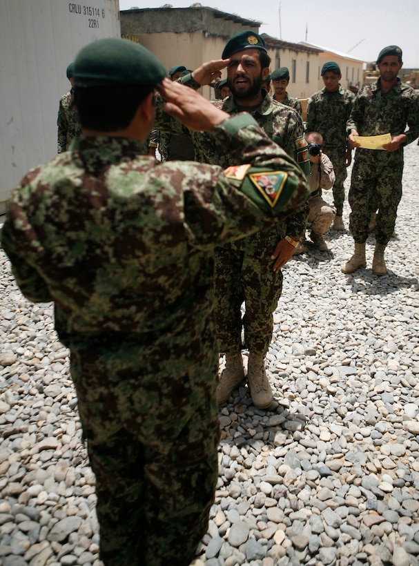 LASHKAR GAH, Afghanistan—Afghan National Army Capt. Mirza Mohammad, commander, Engineering Tolai, 4th Combat Support Kandak, 3rd Brigade, 215th Corps, presents a certificate of achievement to a soldier June 5, 2013, here. The tolai, or company, was the last 215th Corps tolay receiving Security Forces Assistance support. The certificate ceremony signified the end of hands-on Coalition support to the tolai. All SFA provided to units within the 215th Corps is now conducted only at the kandak, or battalion, level and higher.  