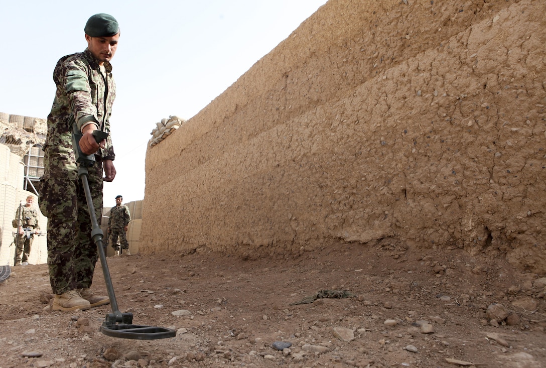 An Afghan National Army soldier uses a metal detector to locate mock improvised explosive devices during an IED lane training course at Patrol Base Sparta June 5. Members of the Kandak Advisor Team 40 held the course to teach members of the Engineering Tolai, 4th Combat Support Kandak, 3rd Brigade, 215 Corps, how to recognize and mark IEDs. (Photo by U.S. Marine Sgt. Bobby J. Yarbrough)