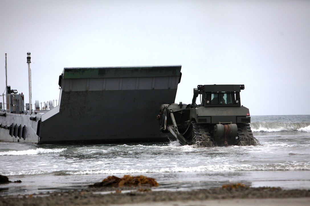 A D7 Dozer pushes a beached landing craft away during a Maritime Prepositioning Force offloading exercise aboard Coronado, Calif., June 13, 2013. The exercise was conducted as part of Dawn Blitz 2013, a joint Marine and Navy amphibious training operation. 