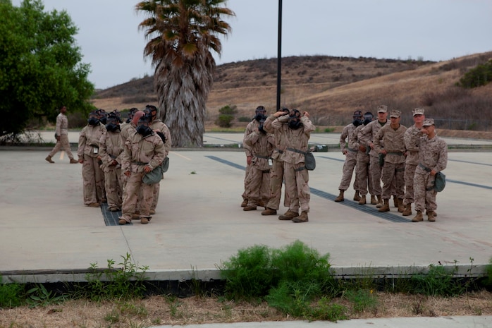 Marines serving with Communications Company, Headquarters Battalion, 1st Marine Division, wait to enter the gas chamber during annual training here, June 12, 2013. While in the chamber, the Marines learned the limitations of their gear by performing basic exercises to get their blood pumping, increase respiratory rates and build confidence that their masks won't come off during movement.