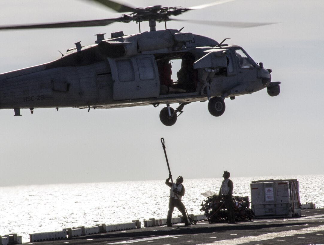 A U.S. Marine assigned to combat cargo aboard the USS Kearsarge (LHD 3) prepares to attach cargo to a Navy MH-60S Seahawk assigned to the LHD 3 during a resupply at sea, June 14, 2013. The 26th MEU is a Marine Air-Ground Task Force forward-deployed to the U.S. 5th Fleet area of responsibility aboard the Kearsarge Amphibious Ready Group serving as a sea-based, expeditionary crisis response force capable of conducting amphibious operations across the full range of military operations. (U.S. Marine Corps photo by Gunnery Sgt. Michael Kropiewnicki, 26th MEU Combat Camera/Released)