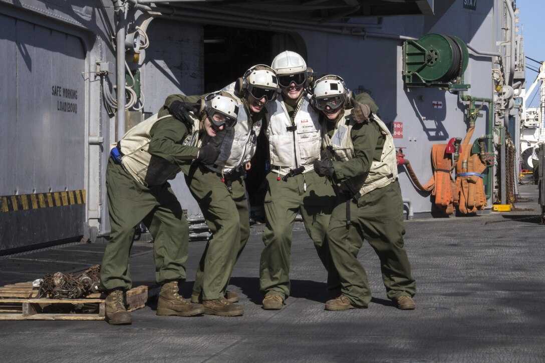 U.S. Marines assigned to combat cargo pose for a photograph aboard the USS Kearsarge (LHD 3) during a resupply at sea, June 14, 2013. The 26th MEU is a Marine Air-Ground Task Force forward-deployed to the U.S. 5th Fleet area of responsibility aboard the Kearsarge Amphibious Ready Group serving as a sea-based, expeditionary crisis response force capable of conducting amphibious operations across the full range of military operations. (U.S. Marine Corps photo by Gunnery Sgt. Michael Kropiewnicki, 26th MEU Combat Camera/Released)