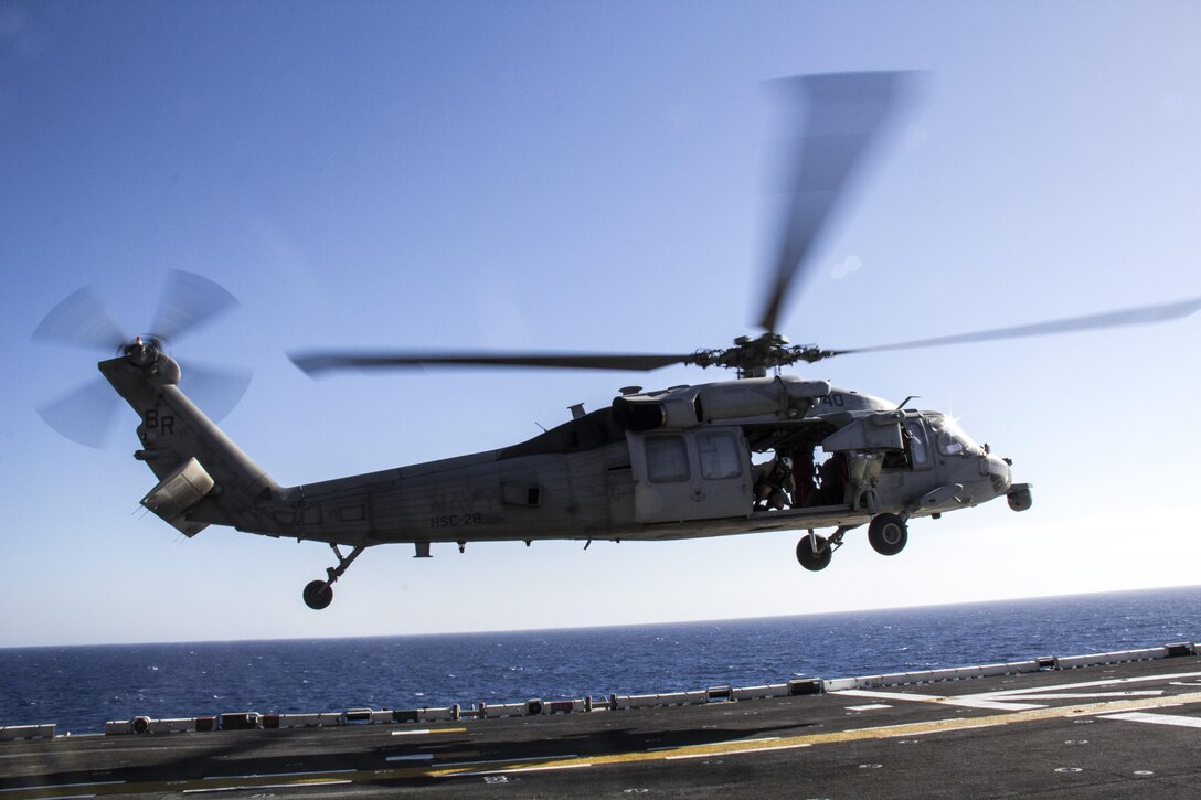 A Navy MH-60S Seahawk assigned to the USS Kearsarge (LHD 3) descends to pick up supplies from the USS Kearsarge (LHD 3) during a resupply at sea, June 14, 2013. The 26th MEU is a Marine Air-Ground Task Force forward-deployed to the U.S. 5th Fleet area of responsibility aboard the Kearsarge Amphibious Ready Group serving as a sea-based, expeditionary crisis response force capable of conducting amphibious operations across the full range of military operations. (U.S. Marine Corps photo by Gunnery Sgt. Michael Kropiewnicki, 26th MEU Combat Camera/Released)