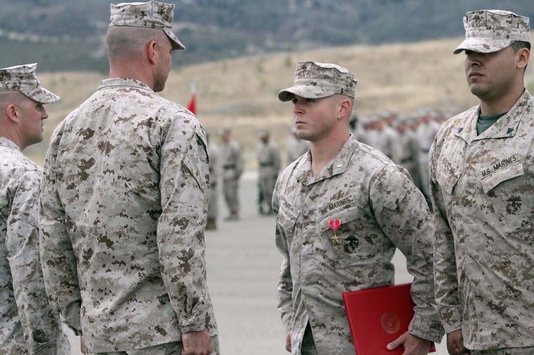 First Lt. Stephen C. Huff, the 81 mm mortar platoon commander serving with 1st Battalion, 1st Marine Regiment, is presented the Bronze Star Medal with Combat "V" for valor here, June 11, 2013. Huff, led more than 50 Marines and Afghan soldiers in an assault on an insurgent stronghold of more than 25 highly trained fighters. During the 60 hour fight, he exposed himself to enemy fire while maneuvering his Marines, directing their fire and evacuating the casualties from the battlefield.