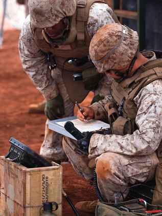 Sgt. Shamar Jackson, a cannoneer with Alpha Battery, 1st Battalion, 12th Marine Regiment, left, calls out repositioning coordinates for their M777 howitzer and the number of artillery shells to launch while Lance Cpl. Thi Nyugen, a cannoneer with Alpha Battery, 1st Bn., 12th Marines, writes down the fire mission during a training exercise at Schofield Barracks, June 11, 2013. Fire missions were sent from command stations behind the firing line, directing the individual teams on each gun coordinates for firing and how many rounds to send downrange. (U.S. Marine Corps photo by Lance Cpl. Matthew Bragg)