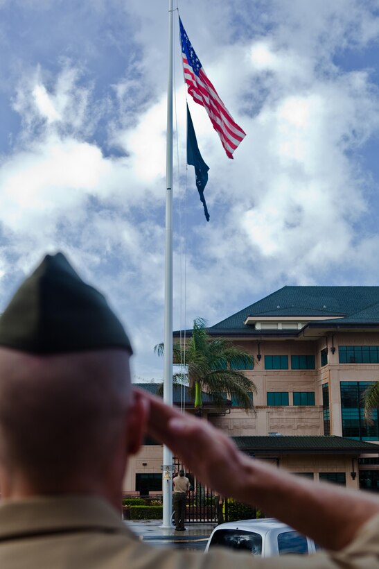CAMP H.M. SMITH, Hawaii - Capt. Joshua W. Connors, U.S. Marine Corps Forces, Pacific Officer of the Day salutes as Marines hoist the U.S. and POW-MIA flag during morning colors June 14, Flag Day.  The POW-MIA flag is customarily flown on Flag Day in accordance with House Resolution 1119.
