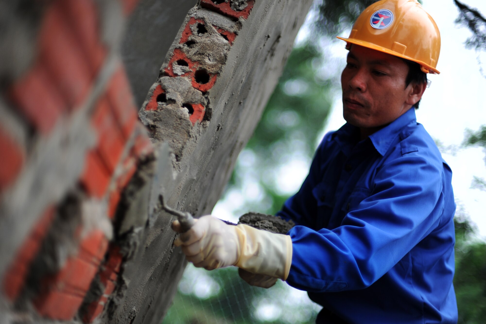 A construction worker with Vietnam People's Army, helps build a small brick building that will be used to burn medical waste, as part of the Engineering Civil Action Programs for Operation Pacific Angel 13-3 in Dong Hoi, Quang Binh Province, Vietnam, June 12, 2013. U.S. and Vietnam military members joined together to complete construction projects on one medical clinic and two schools in Vietnam. Operation PACANGEL is a joint and combined humanitarian assistance exercise held in various countries several times a year and includes medical, dental, optometry, engineering programs and a variety of subject-matter expert exchanges. (U.S. Air Force photo by Staff Sgt. Sara Csurilla)