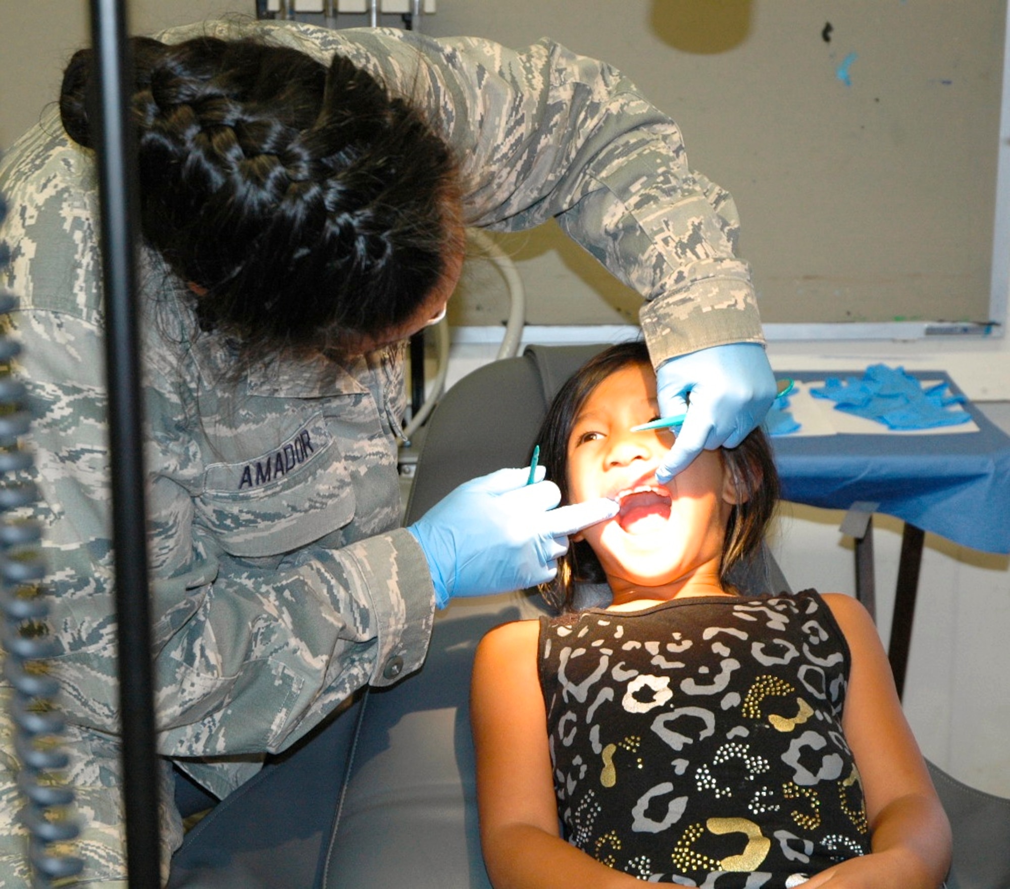 Lt. Col. Xochitl Amador, a dentist serving with the 482nd Medical Squadron at Homestead Air Reserve Base, Fla., examines a young patient's teeth during TROPICARE 13, a Reserve component medical Innovative Readiness Training event that took place in communities throughout the Hawaiian islands, June 2-15, 2013. Five hundred Guard and Reserve medical personnel worked with local health agencies and community organizations to provide free medical, dental and vision care to underserved citizens there. (U.S. Air Force photo / Dana Lineback)  