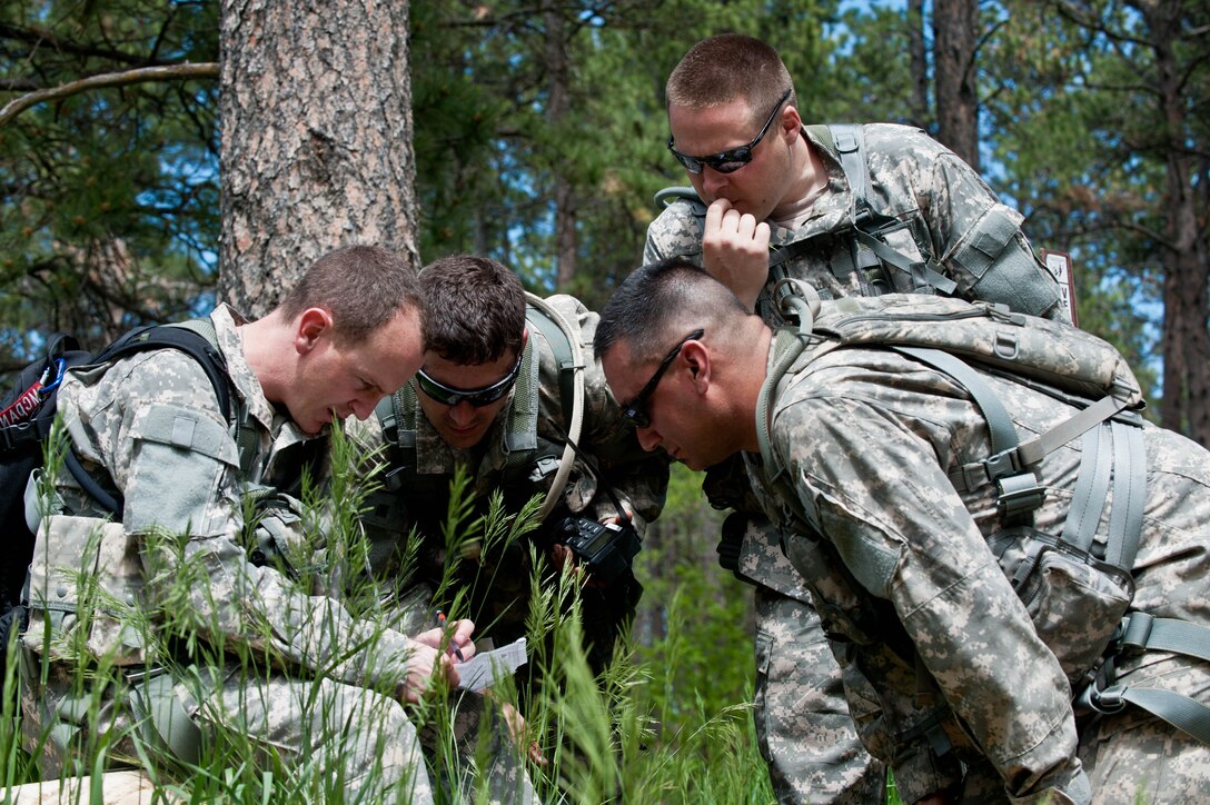 South Dakota National Guard soldiers from B Company 1-112 review their maps, equipment and radio frequencies during survival, evasion, resistance and escape training at the Fort Meade training range in Sturgis, S.D., June 10, 2013. The training is designed to teach aircrews and other personnel to implement survival techniques while evading enemy forces. (U.S. Air Force photo by Airman 1st Class Zachary Hada/Released)