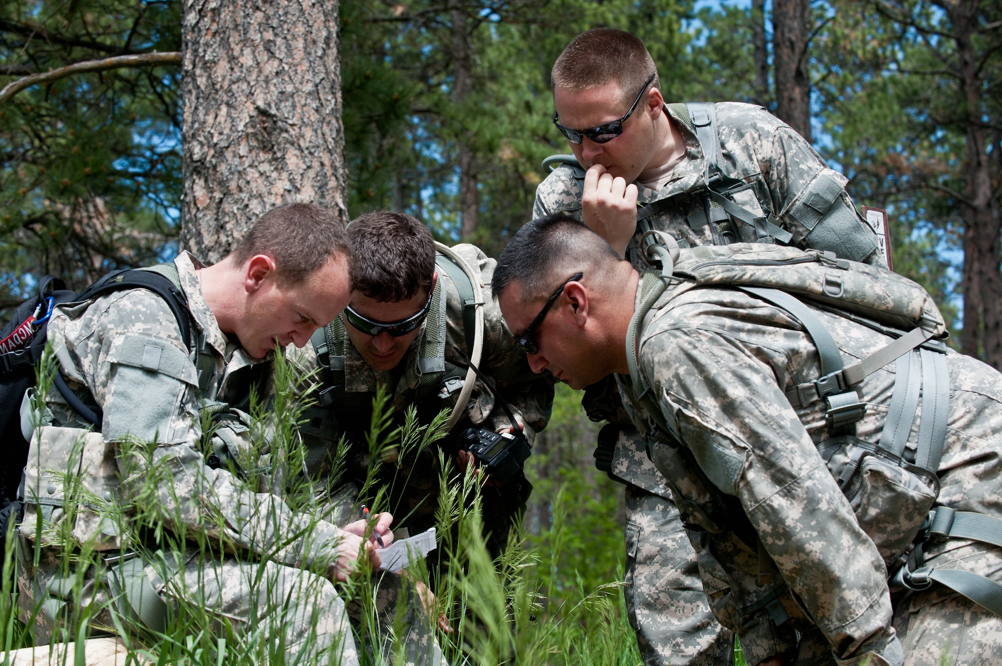South Dakota National Guard soldiers from B Company 1-112 review their maps, equipment and radio frequencies during survival, evasion, resistance and escape training at the Fort Meade training range in Sturgis, S.D., June 10, 2013. The training is designed to teach aircrews and other personnel to implement survival techniques while evading enemy forces. (U.S. Air Force photo by Airman 1st Class Zachary Hada/Released)