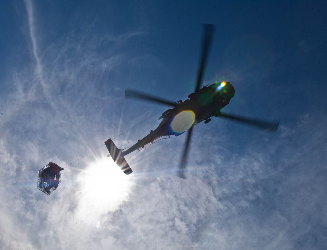 A HH-60 Black Hawk flown by a South Dakota National Guard medical evacuation aircrew hoists a soldier from the  SDANG B Company 1-112 during survival, evasion, resistance and escape training at the Fort Meade training range in Sturgis, S.D., June 10, 2013. This joint exercise, coordinated by Air Force SERE specialists, challenged teams to navigate different checkpoints throughout the training range and be rescued. (U.S. Air Force photo by Airman 1st Class Zachary Hada/Released)