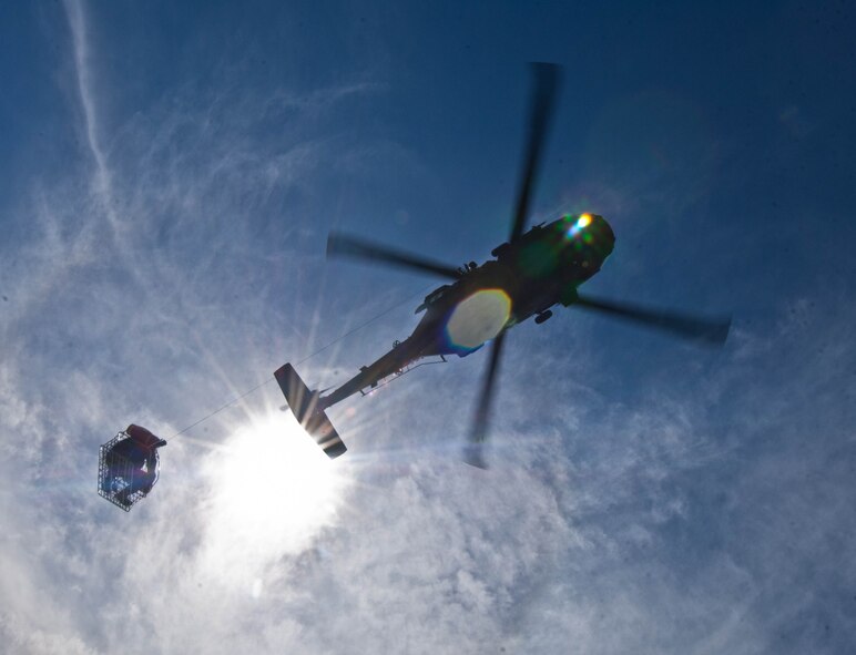 A HH-60 Black Hawk flown by a South Dakota National Guard medical evacuation aircrew hoists a soldier from the  SDANG B Company 1-112 during survival, evasion, resistance and escape training at the Fort Meade training range in Sturgis, S.D., June 10, 2013. This joint exercise, coordinated by Air Force SERE specialists, challenged teams to navigate different checkpoints throughout the training range and be rescued. (U.S. Air Force photo by Airman 1st Class Zachary Hada/Released)