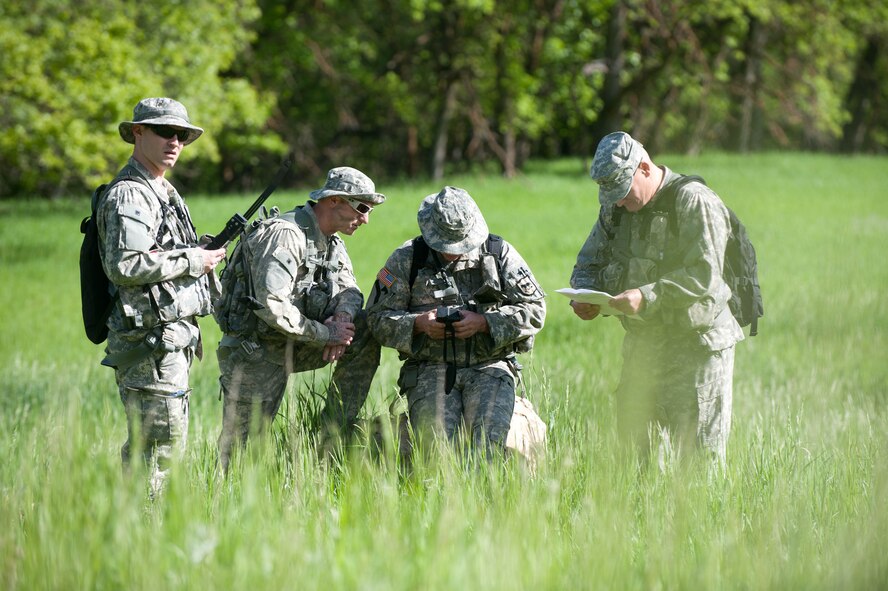 South Dakota National Guard soldiers from B Company 1-112 review maps, equipment and radio frequencies during survival, evasion, resistance and escape training at the Fort Meade training range in Sturgis, S.D., June 10, 2013. During the training, participants had to vector helicopters with radios, practiced medical extraction techniques and performed evasion tactics throughout the training range while evading an aggressive force. (U.S. Air Force photo by Airman 1st Class Zachary Hada/Released)