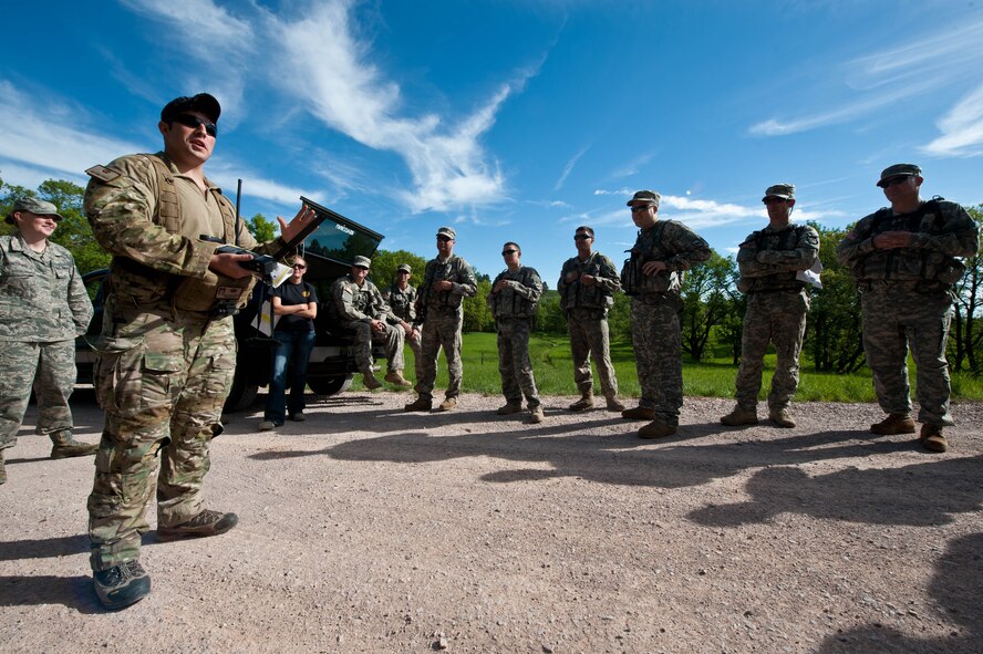 Staff Sgt. Zachary Yoakam, 28th Operations Support Squadron survival, evasion, resistance and escape specialist, briefs soldiers from South Dakota National Guard B Company 1-112 on SERE training and tactics during a joint exercise at the Fort Meade training range in Sturgis, S.D., June 10, 2013. Yoakam ensured the participants understood the training rules and guidelines for the survival exercise conducted as part of Golden Coyote. (U.S. Air Force photo by Airman 1st Class Zachary Hada/Released)