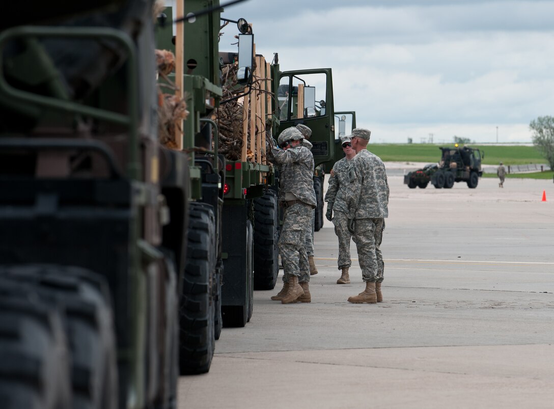 Soldiers from the 1074th Transportation Company, Broken Bow, Neb., secure loads of timber during a South Dakota National Guard exercise called Golden Coyote at Ellsworth Air Force Base, S.D., June 12, 2013. The Nebraska National Guard transported five beds of timber to the Pine Ridge Indian Reservation that residents will use to help warm their houses in the winter. (U.S. Air Force photo by Airman 1st Class Alystria Maurer/Released)