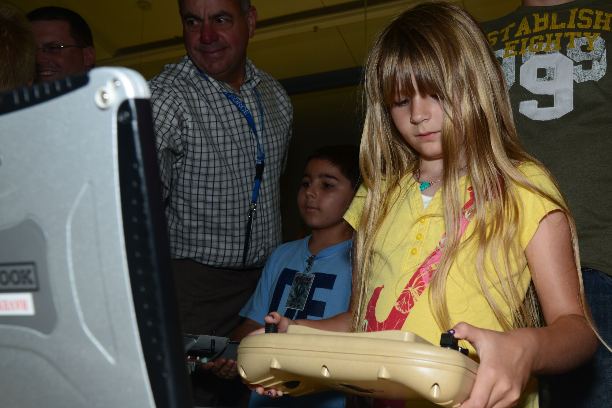 Evie Cumming, 7, daughter of Maj. Louis Cumming, Air Force Special Operations Command Inspector General, plays with a small unmanned aircraft system control during AFSOC’s “Bring Your Kids to Work Day” at Hurlburt Field, Fla., June 14, 2013. Children saw their parents' work centers, visited the airpark, and attended the AFSOC picnic. (U.S. Air Force photo/Staff Sgt. Melanie Holochwost)
