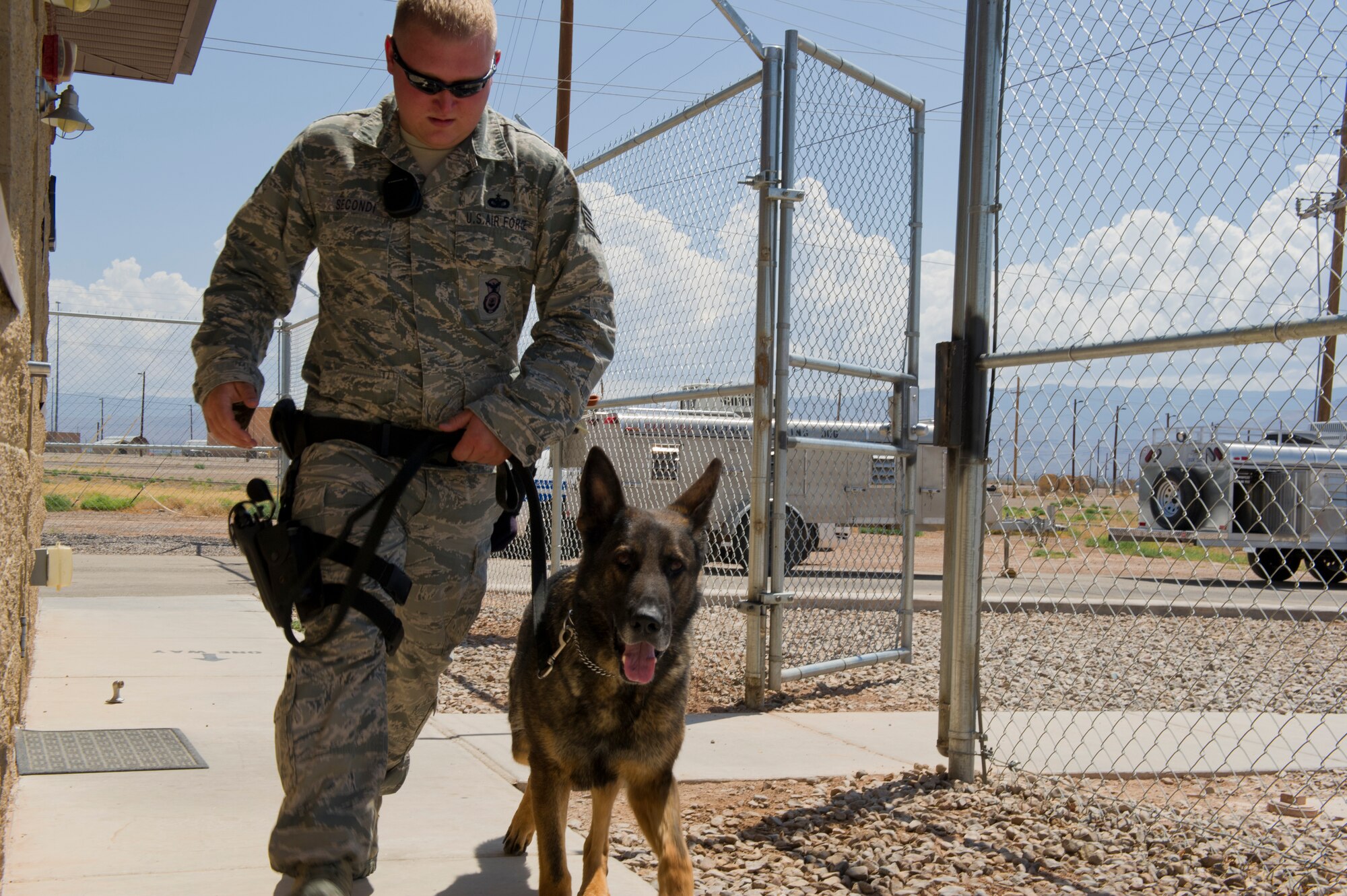 Staff Sgt. Christopher Secondi, 49th Security Forces Squadron K-9 handler, runs back to the kennel after a day of training exercises with Military Working Dog Falco at Holloman Air Force Base, N.M., June 14. K-9 handlers and military working dogs are trained for situations both in and out of combat. (U.S. Air Force photo by Airman 1st Class Aaron Montoya/Released)
