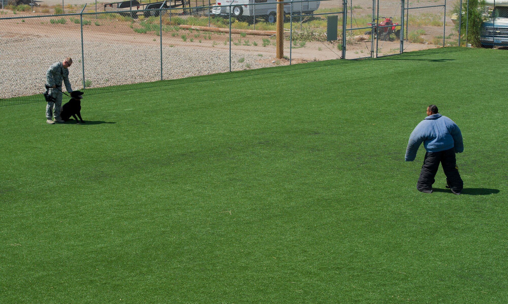Staff Sgts. Christopher Secondi and Krystle Draper, 49th Security Forces Squadron K-9 handlers, prepare for an aggression training exercise with Military Working Dog Vulkan at Holloman Air Force Base, N.M., June 14. During aggression training, military working dogs practice taking down a decoy target played by another K-9 handler in preparation for the apprehension of an actual suspect. (U.S. Air Force photo by Airman 1st Class Aaron Montoya/Released)