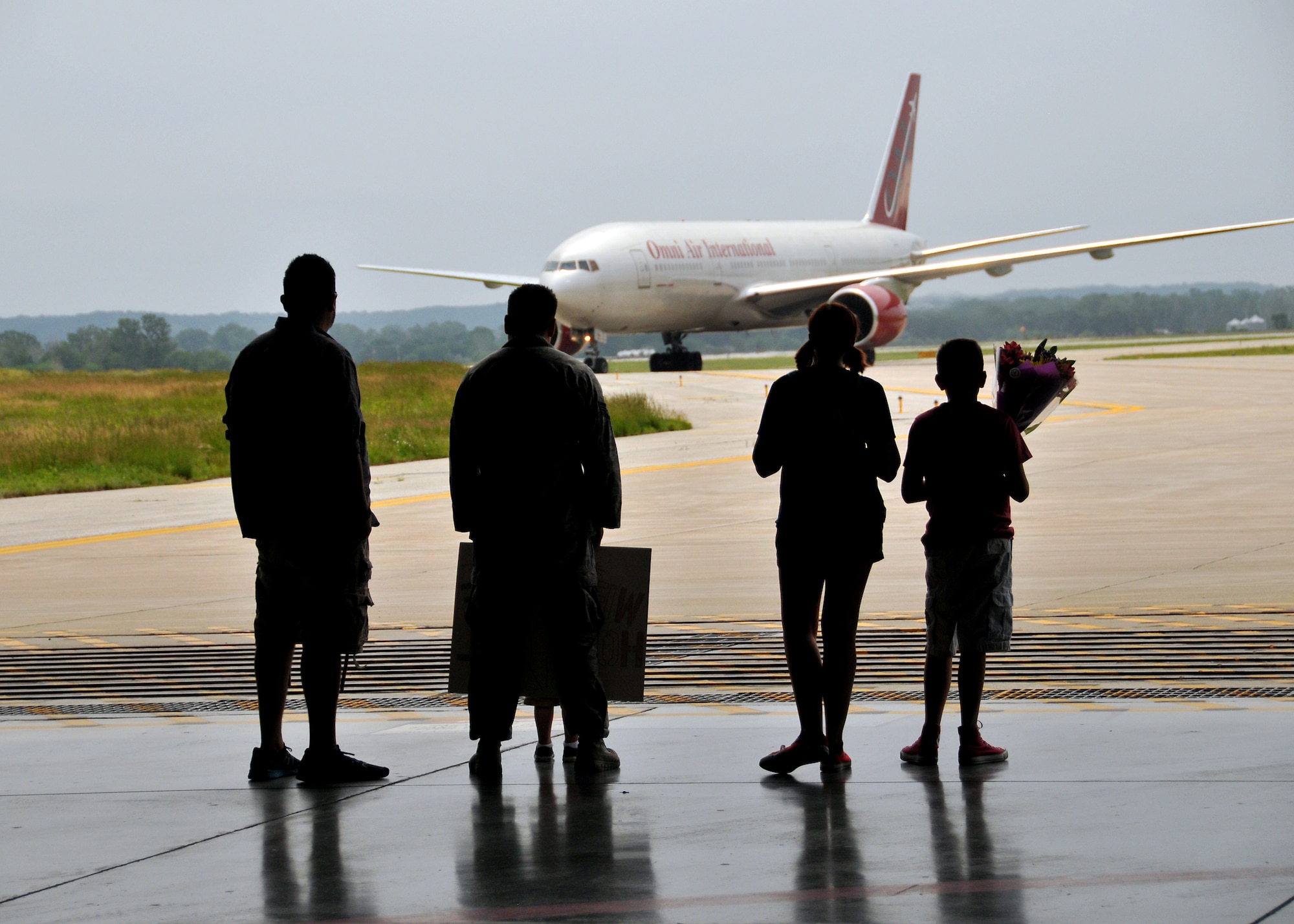 Family members of a U.S. Air Force staff sergeant assigned to the 343rd Reconnaissance Squadron wait for arrival at the Bennie Davis Maintenance Facility at Offutt Air Force Base, Neb., June 14. Team Offutt family members, friends and coworkers welcomed nearly 200 Airmen upon their return from a deployment to Southwest Asia. (U.S. Air Force photo by Tech. Sgt. Markus M. Maier/Released)