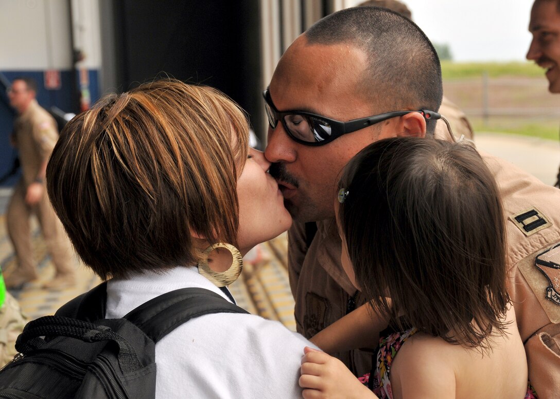 A U.S. Air Force captain assigned to the 343rd Reconnaissance Squadron kisses his wife Squadron in the Bennie Davis Maintenance Facility at Offutt Air Force Base, Neb., June 14. Team Offutt family members, friends and coworkers welcomed nearly 200 Airmen upon their return from a deployment to Southwest Asia. (U.S. Air Force photo by Tech. Sgt. Markus M. Maier/Released)