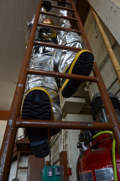 Staff Sgt. Adam Mercer, 2nd Civil Engineer Squadron, climbs a ladder as a part of his annual self contained breathing apparatus certification on Barksdale Air Force Base, La., June 13, 2013. The SCBA certification tests firefighters on proper breathing techniques. (U.S. Air Force photo/Senior Airman Micaiah Anthony)