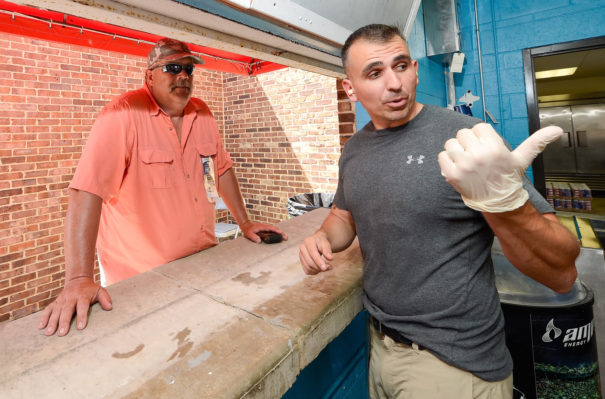 Master Sgt. Rick Dumont, (right) of the 9th Airlift Squadron, shows a customer what type of food items are being sold at the concession stand he is working on June 1, 2013 at Dover International Speedway. Dumont is working the concession stand as part of a squadron fundraiser during the running of the NASCAR Nationwide Series race. Volunteers' from nearby Dover Air Force Base participated in many ways to support the large event. (U.S. Air Force photo/Greg L. Davis)