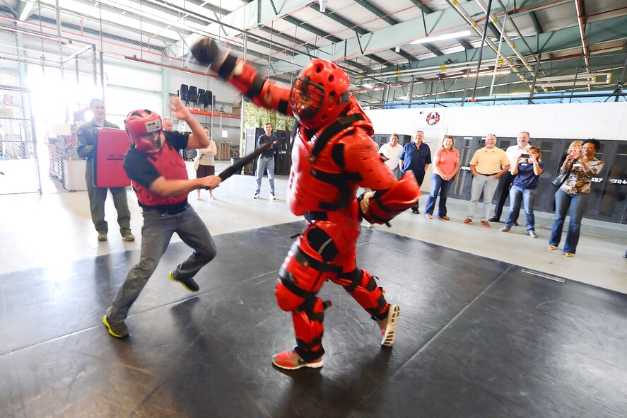 Mr. John Matarese, Honorary Commander for the 709th Airlift Squadron, (wearing jeans) weilds a simulated ASP baton while sparring with a 436th Security Forces Squadron member wearing a protective red suit to experience some of the training Raven's go through during an in-depth tour of Dover Air Force Base, Delaware's 436th Security Forces Squadron, June 5, 2013.  (U.S. Air Force photo/Greg L. Davis)