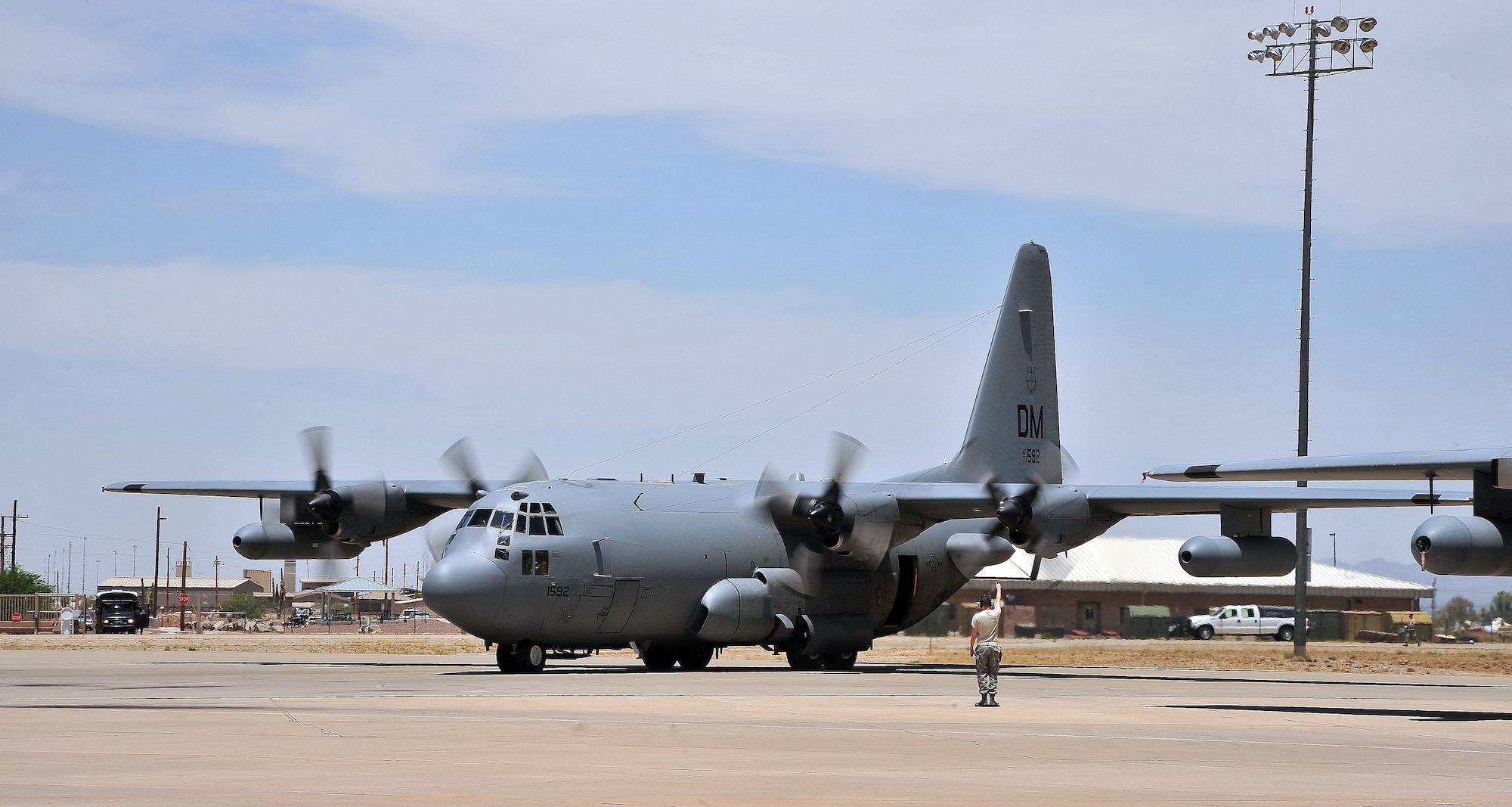 A U.S. Air Force Airman from the 755th Aircraft Maintenance Squadron, guides in an EC-130H at Davis-Monthan Air Force Base, Ariz., June 12, 2013. The 755th Aircraft Maintenance Squadron provides war-fighting commanders with combat ready EC-130H Compass Call aircraft to expeditiously execute information warfare and electronic attack operations.(U.S Air Force photo by Airman 1st Class Josh Slavin/Released)