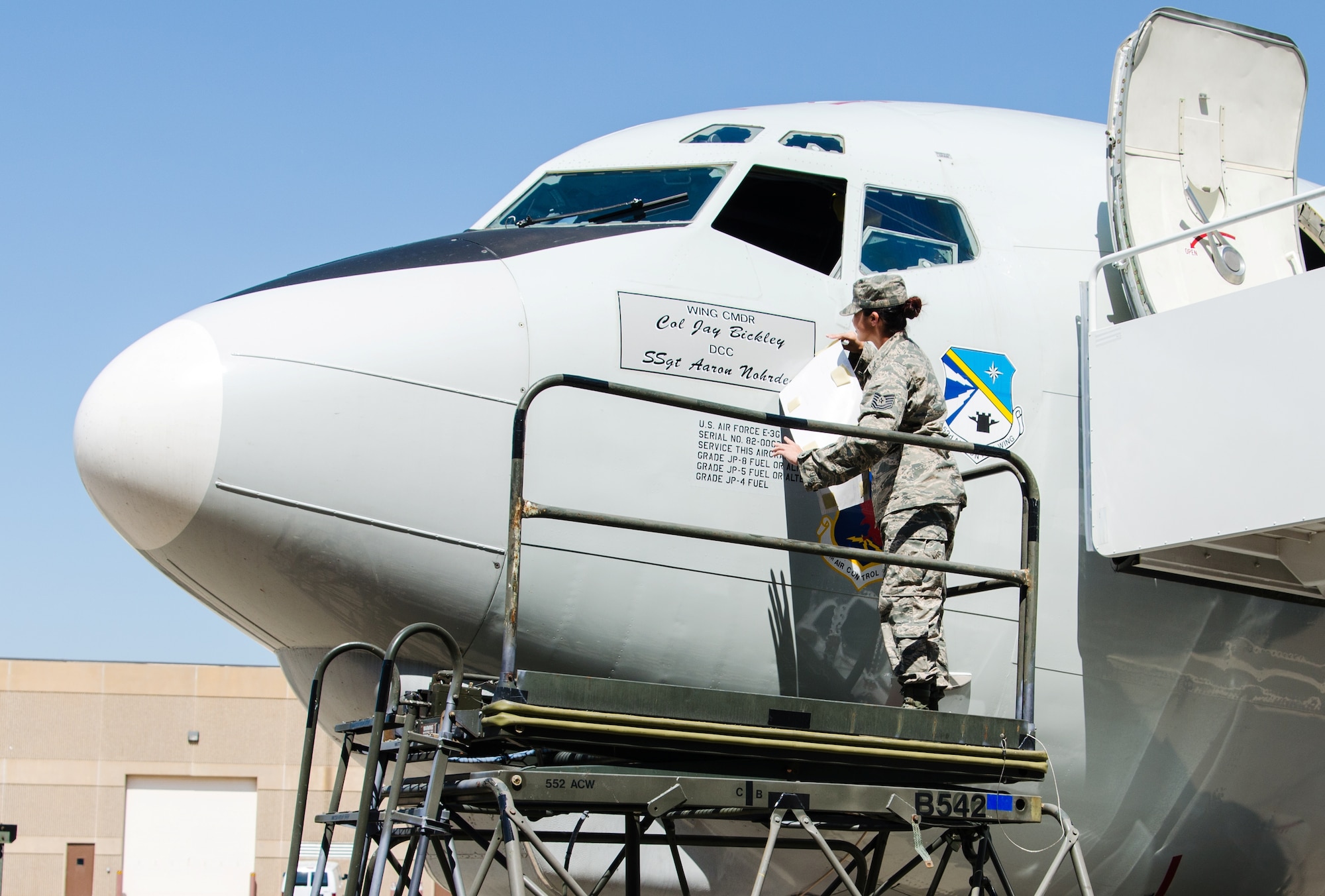 Tech Sgt. Victoria Stewart, a dedicated crew chief with the 552nd Aircraft Maintenance Squadron reveals the name of the 552nd Air Control Wing’s new commander, Col. Jay Bickley on an E-3 Airborne Warning and Control System aircraft here, June 13.  Col. Bickley now commands more than 5,000 men and women, providing worldwide command and control operating the E-3 AWACS and ground based Control and Reporting Centers. (U.S. Air Force Photo/Senior Airman Kristopher Gooden) 